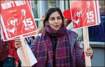 Kshama Sawant, Socialist Seattle councillor, hands out placards at protest for $15 an hour, photo Socialist Alternative