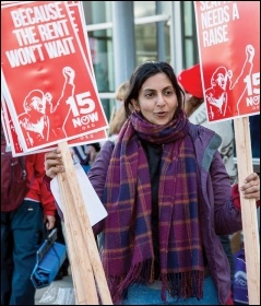 Kshama Sawant, Socialist Seattle councillor, hands out placards at protest for $15 an hour, photo Socialist Alternative