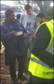 Bus drivers reading the Socialist Party strike bulletin at Northumberland Park garage, photo by Jim Horton