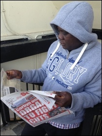Resident reads the Socialist while defending the blocks, photo by Paula Mitchell
