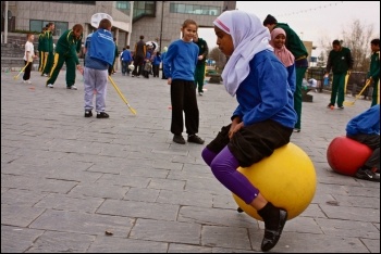 Primary school children playing outside on space hoppers, photo National Assembly for Wales (Creative Commons)