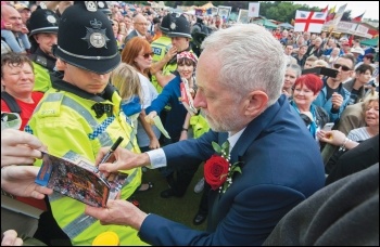 Jeremy Corbyn signing an autograph for a supporter - his policies are rightly popular, but if he wins, he will face opposition from the billionaire class, the Blairites and the state, photo Paul Mattsson
