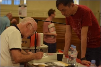 Peter Taaffe signing a copy of his new book, London launch meeting, 25.5.17, photo by Mary Finch