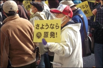 Protesters in Japan march with signs reading 'goodbye nuclear power,' photo by James Clement