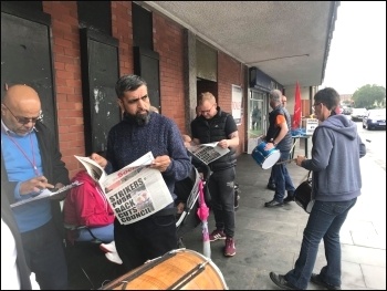 Bus strikers reading the Socialist, photo by T. Costello