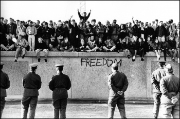 Students atop of the Wall at the Brandenburg gate during the dying days of the East German regime