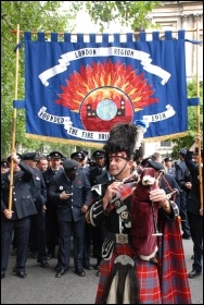 2,500 uniformed firefighters marched with Fire Brigades Union (FBU) flags and placards, whistles and vuvuzelas, and even a bagpiper, to protest outside the London Fire Authority (LFA)., photo by Suzanne Beishon