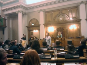 Rob Williams, National Shop Stewards Network anti-cuts convenor, addresses protesters who invaded Lambeth Council's budget meeting, photo by Lambeth  Socialist Party
