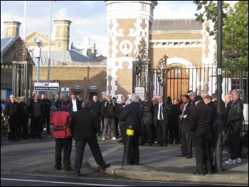 Prison officers outside Wormwood Scrubs prison listening to Socialist Party member Keith Dickinson address them using a megaphone on 30th November 2011 