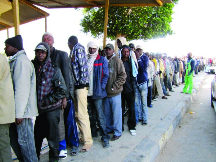 Migrant workers at the Egypt-Libya border queue for food relief. Photo: EU CPHA/CC