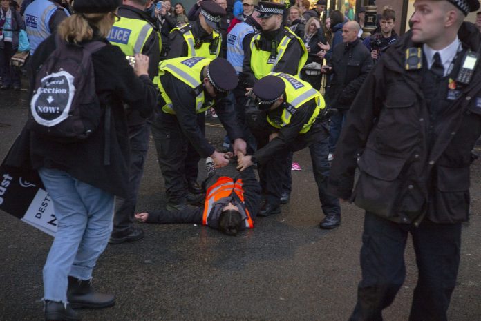 Police arrest a Just Stop Oil protester. Photo: {aul Mattsson