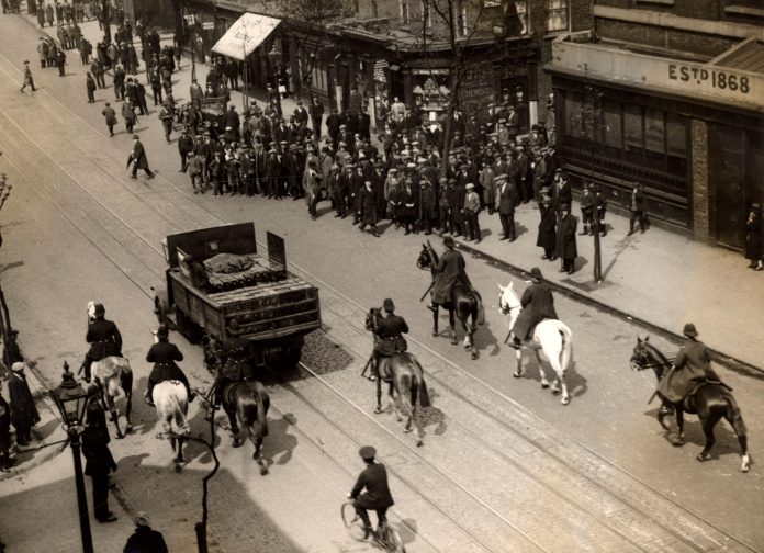 Algemene_staking_in_Engeland_1926,_SFA022820553 A lorry loaded with cans of petrol is escorted and guarded by six mounted police officers on its way to a warehouse, passing striking workers Photo: Public domain